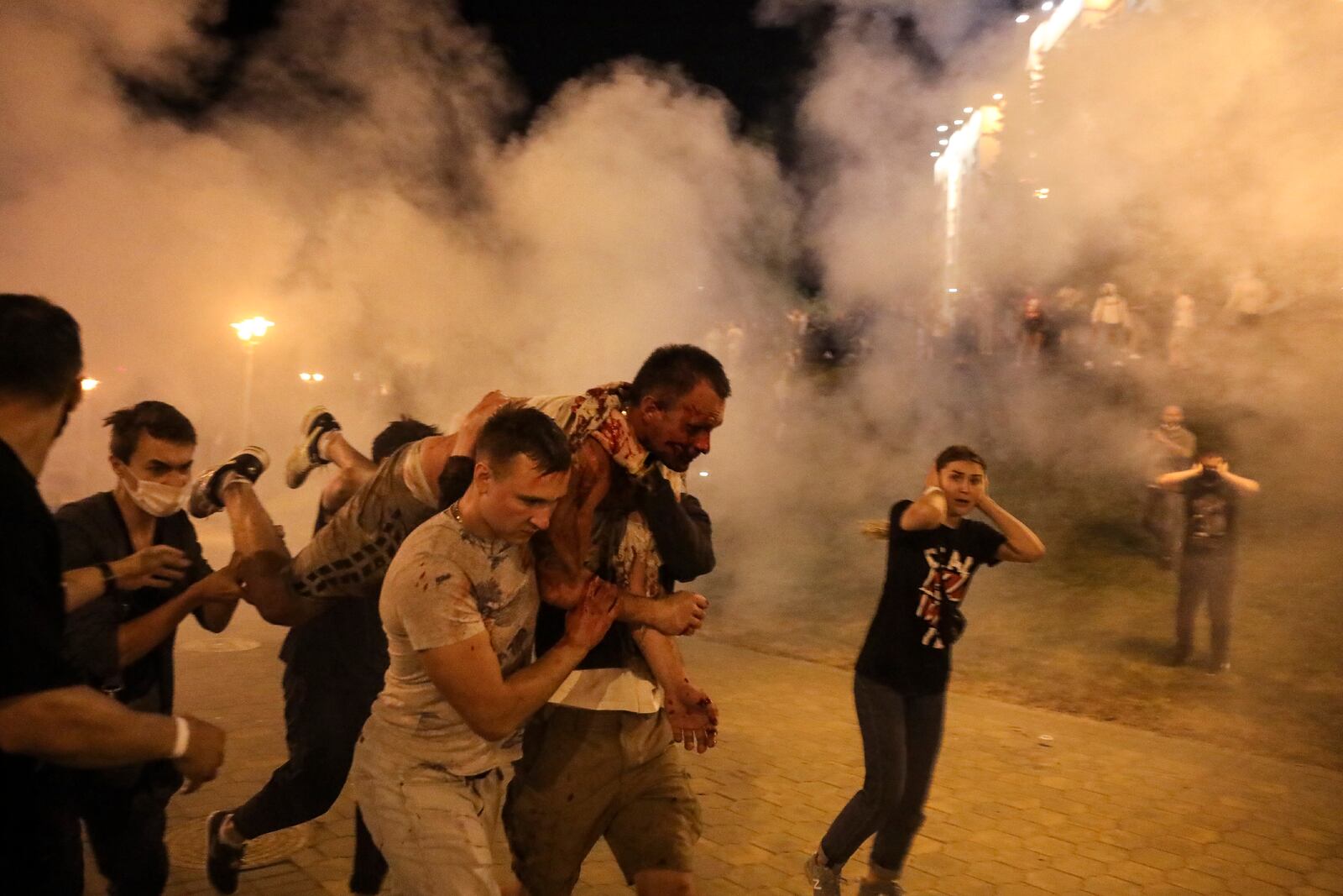 FILE - Protesters carry a man injured during clashes with police amid anti-government demonstrations in Minsk, Belarus, on Aug. 10, 2020. (AP Photo, File)