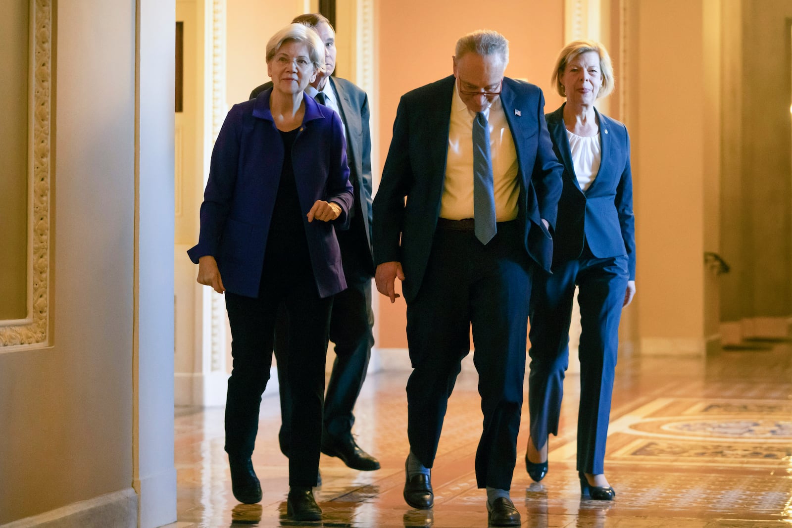 Senators, from left, Sen. Elizabeth Warren, D-Mass., Senate Majority Leader Chuck Schumer of N.Y., and Sen. Tammy Baldwin, D-Wis., gather after Senate Democratic leadership elections for the next session of Congress on Capitol Hill, Tuesday, Dec. 3, 2024, in Washington. (AP Photo/Mark Schiefelbein)