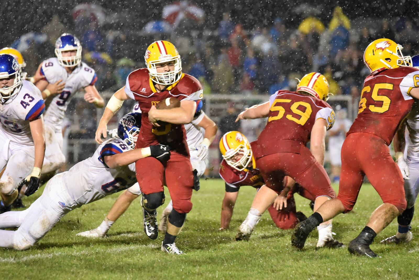 Fenwick’s Jack Fessler (3) cuts through the rain and Clinton-Massie defense as he gets some blocking help from teammates Leo Bell (59) and Justin Duckwall (65) during Friday night’s game at Krusling Field in Middletown. Fenwick dropped a 21-18 decision. CONTRIBUTED PHOTO BY ANGIE MOHRHAUS