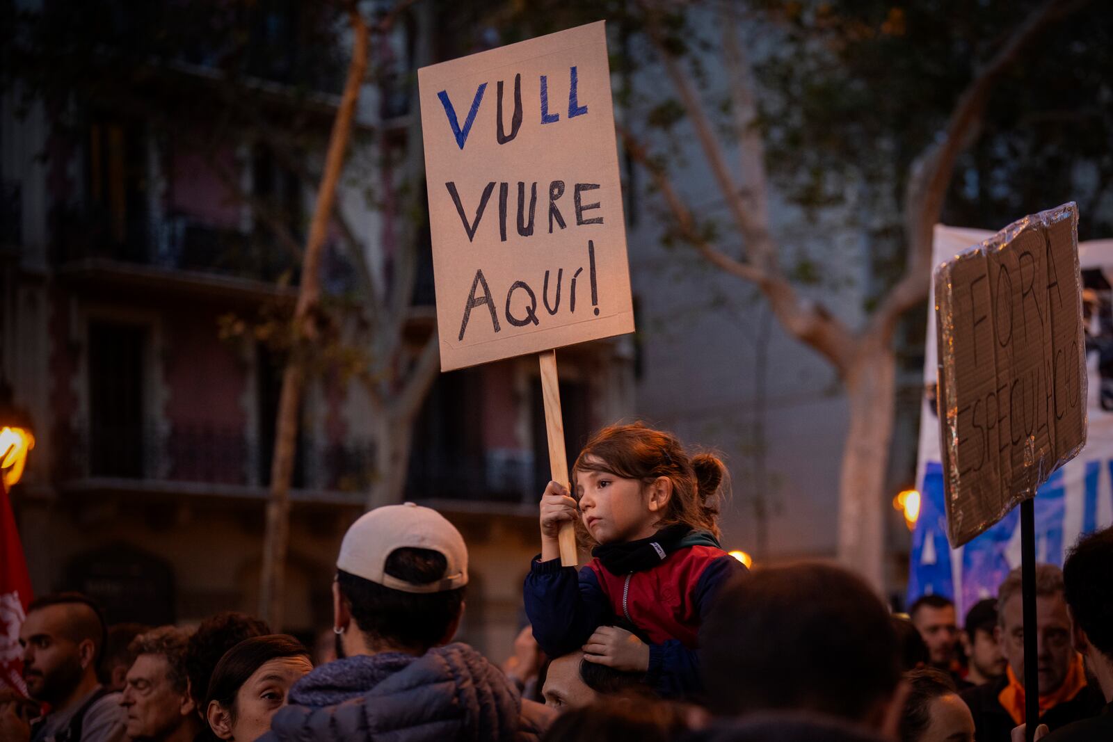 Oscar, 6, holds a sign reading in Catalan "I want to live here" as they protest the skyrocketing cost of renting an apartment in Barcelona, Spain, Saturday, Nov. 23, 2024. (AP Photo/Emilio Morenatti)