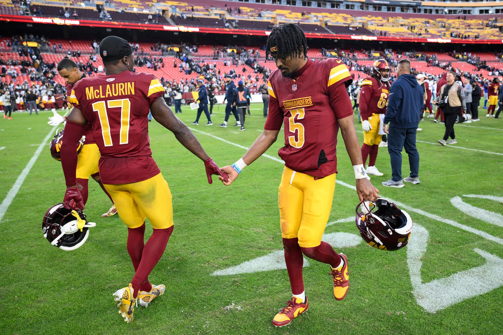 Washington Commanders quarterback Jayden Daniels (5) and wide receiver Terry McLaurin (17) walk across the field after the 34-26 loss to the Dallas Cowboys of an NFL football game, Sunday, Nov. 24, 2024, in Landover, Md. (AP Photo/Nick Wass)