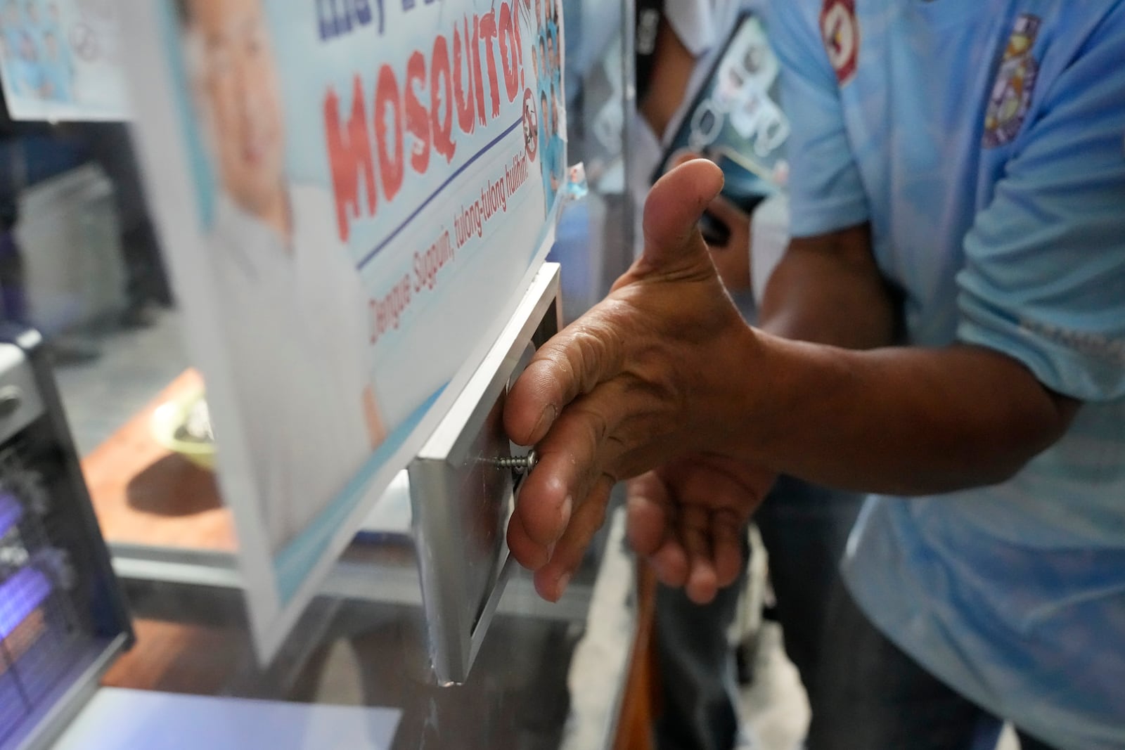 A captured mosquito is transferred to a glass enclosure with UV light trap in Mandaluyong city, Philippines as the village started offering bounty for captured mosquitos, dead or alive, as part of an anti-dengue campaign on Wednesday, Feb. 19, 2025. (AP Photo/Aaron Favila)