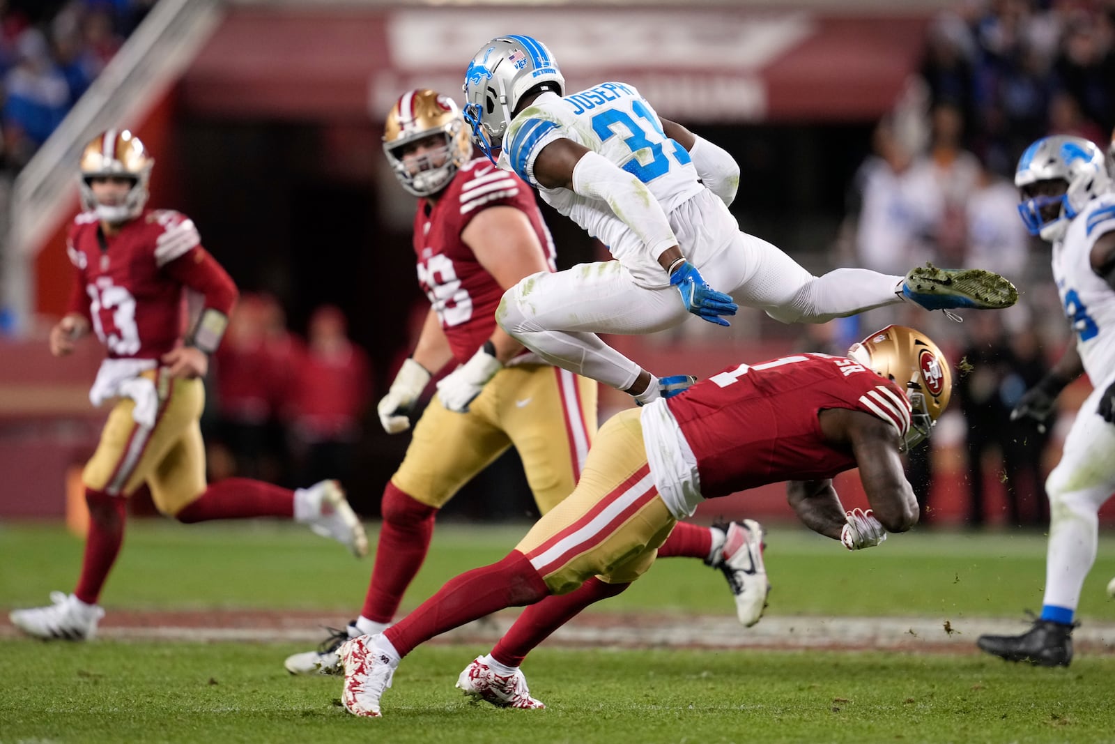 Detroit Lions safety Kerby Joseph (31) leaps over San Francisco 49ers wide receiver Deebo Samuel Sr. (1) after intercepting a pass during the second half of an NFL football game Monday, Dec. 30, 2024, in Santa Clara, Calif. (AP Photo/Godofredo A. Vásquez)