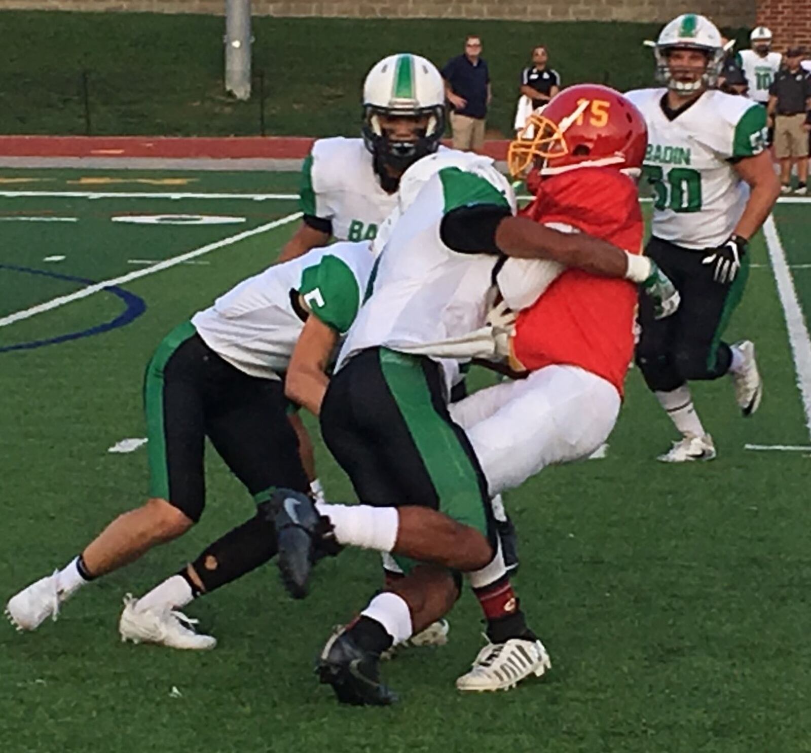 Purcell Marian’s Bryan Williams (15) is tackled by Davon Starks and Marshall Flaig (5) of Badin on Sept. 16, 2017, at Walnut Hills’ Marx Stadium. The visiting Rams won 42-12. RICK CASSANO/STAFF