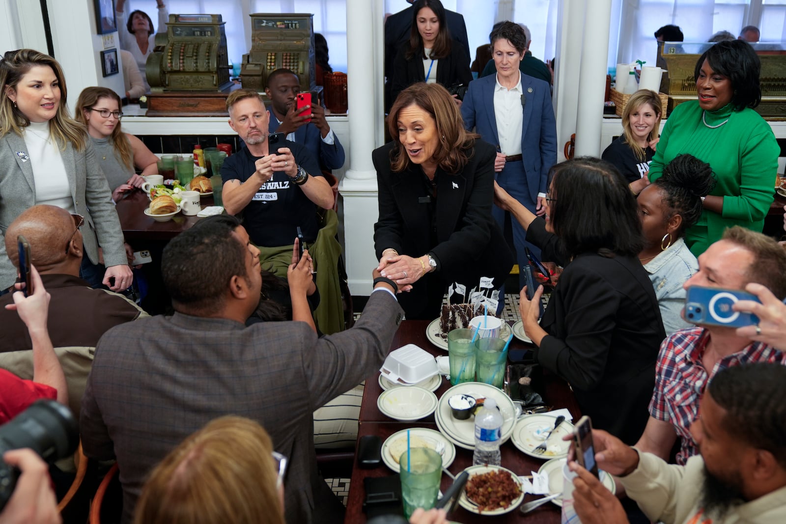 Democratic presidential nominee Vice President Kamala Harris, with Philadelphia Mayor Cherelle Parker, right, speaks to workers and patrons at a campaign stop at Famous 4th Street Delicatessen in Philadelphia, Wednesday, Oct. 23, 2024. (AP Photo/Matt Rourke)