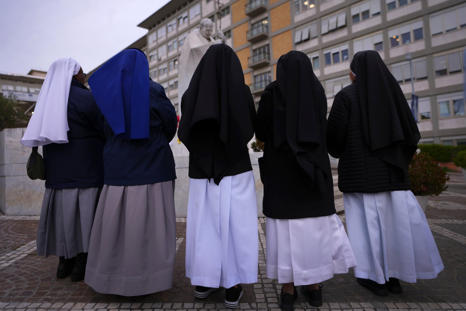 People pray for Pope Francis in front of the Agostino Gemelli Polyclinic, where the Pontiff has been hospitalized since Feb. 14, in Rome, Wednesday, Feb. 26, 2025. (AP Photo/Kirsty Wigglesworth)