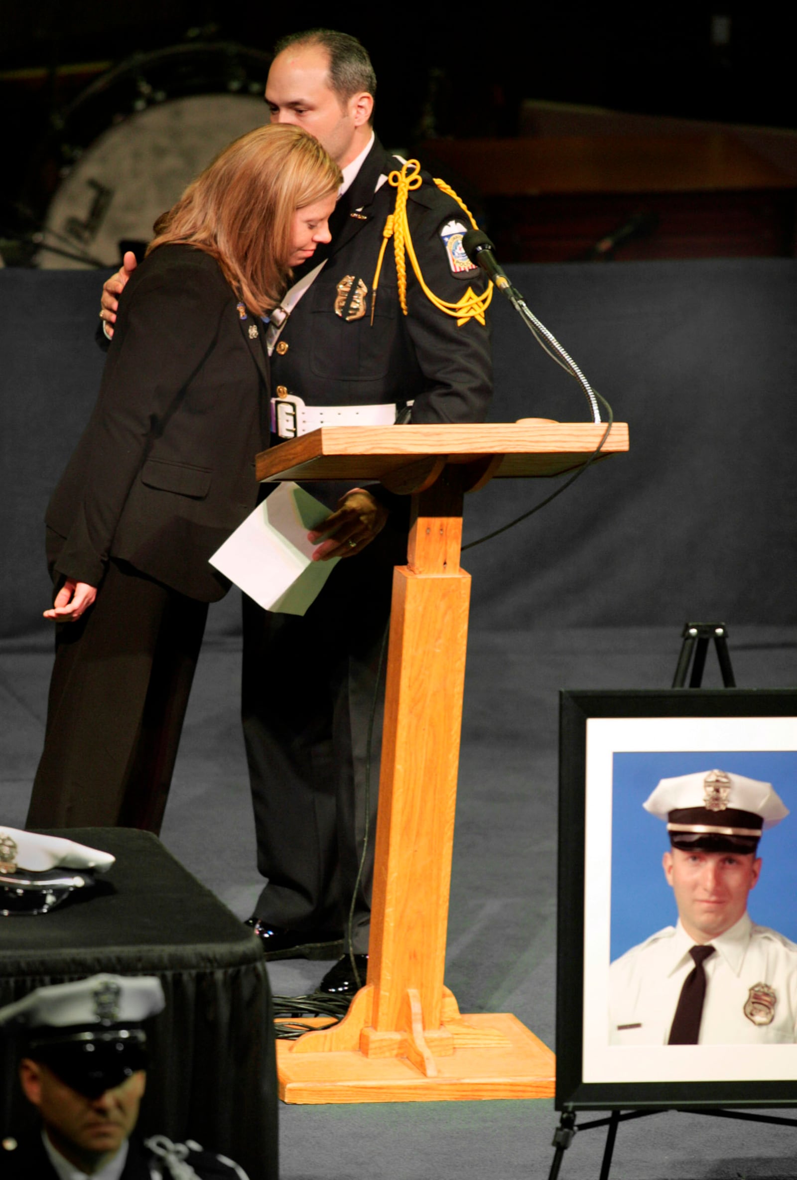 FILE - Marissa Hurst, wife of slain officer Bryan Hurst, left, hugs Sgt. Donnie Oliverio, after Oliverio paid tribute to Bryan, during a service in Columbus, Ohio, on Jan. 11, 2005. (Fred Squillante/The Columbus Dispatch via AP, File)