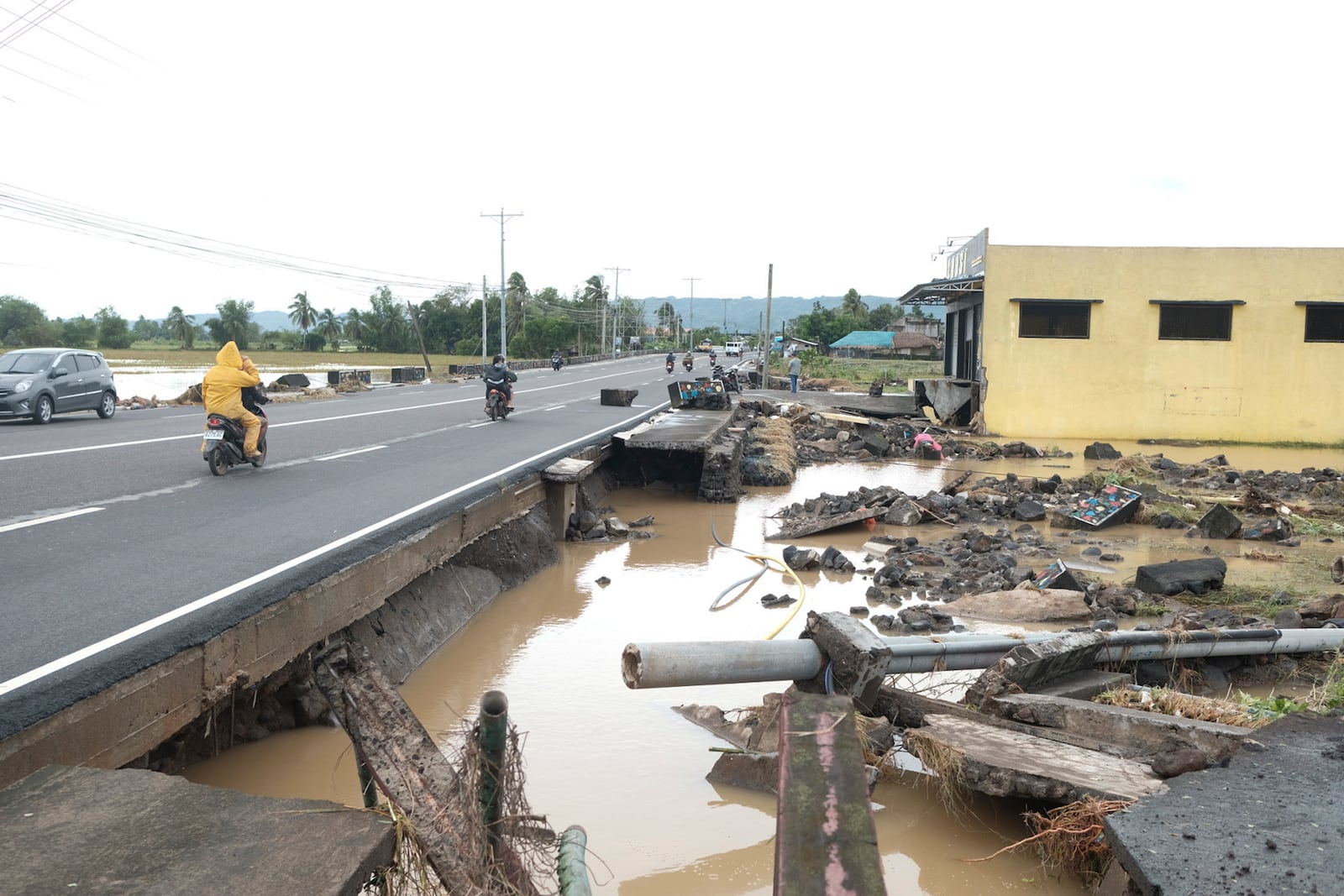 Debris from a damaged road and electric posts caused by Tropical Trami, locally named Kristine, in Polangui, Albay province, Philippines on Oct. 23, 2024. (AP Photo/John Michael Magdasoc)