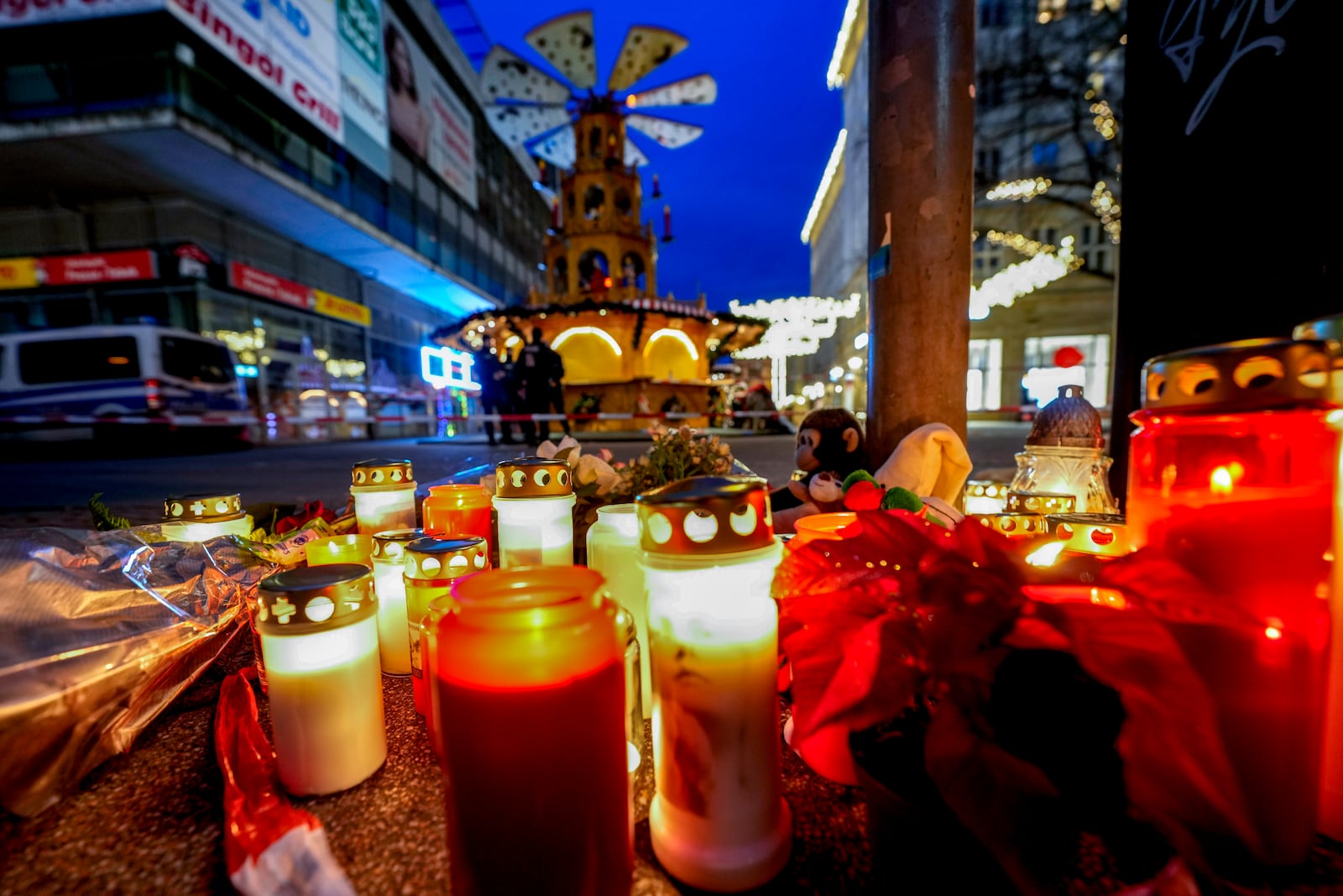 People have lit candles at the Christmas Market in Magdeburg, Germany on Saturday evening , Dec. 21, 2024, where a car drove into a crowd on Friday evening, . (AP Photo/Michael Probst)