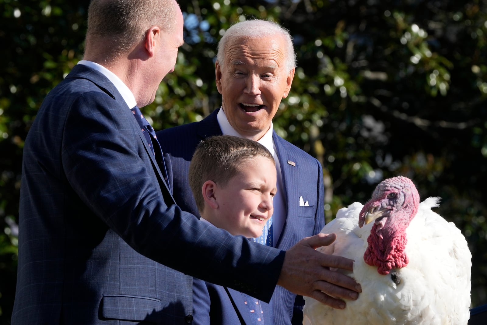 President Joe Biden is pictured with John Zimmerman, chair of the National Turkey Federation, from left, and Zimmerman's son Grant, after pardoning the national Thanksgiving turkey Peach during a ceremony on the South Lawn of the White House in Washington, Monday, Nov. 25, 2024. (AP Photo/Mark Schiefelbein)