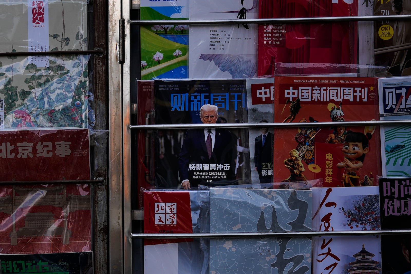 A magazine carrying a front cover of President Donald Trump with the words "Trump shock again" on display with other magazines at a bookstand in Beijing, Tuesday, Feb. 4, 2025. (AP Photo/Andy Wong)