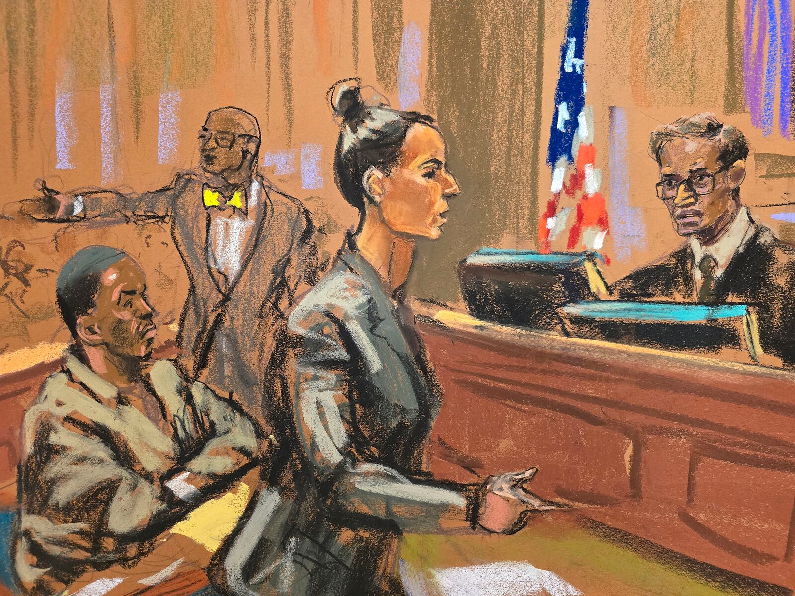 In this courtroom sketch, Assistant United States Attorney Christy Slavic, standing center, speaks during a hearing for Sean "Diddy" Combs, left, as Judge Arun Subramanian, right, presides in federal Court, Friday, Nov. 22, 2024, in New York. Attorney Tony Riccio is shown standing background center. (Jane Rosenberg via AP)