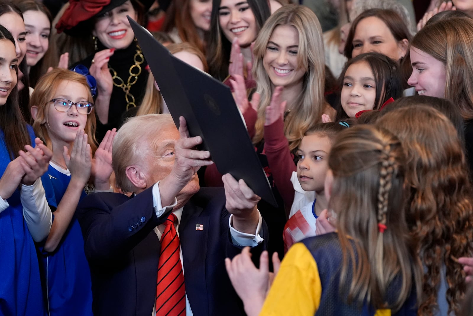 President Donald Trump holds up a signed executive order barring transgender female athletes from competing in women's or girls' sporting events, in the East Room of the White House, Wednesday, Feb. 5, 2025, in Washington. (AP Photo/Alex Brandon)