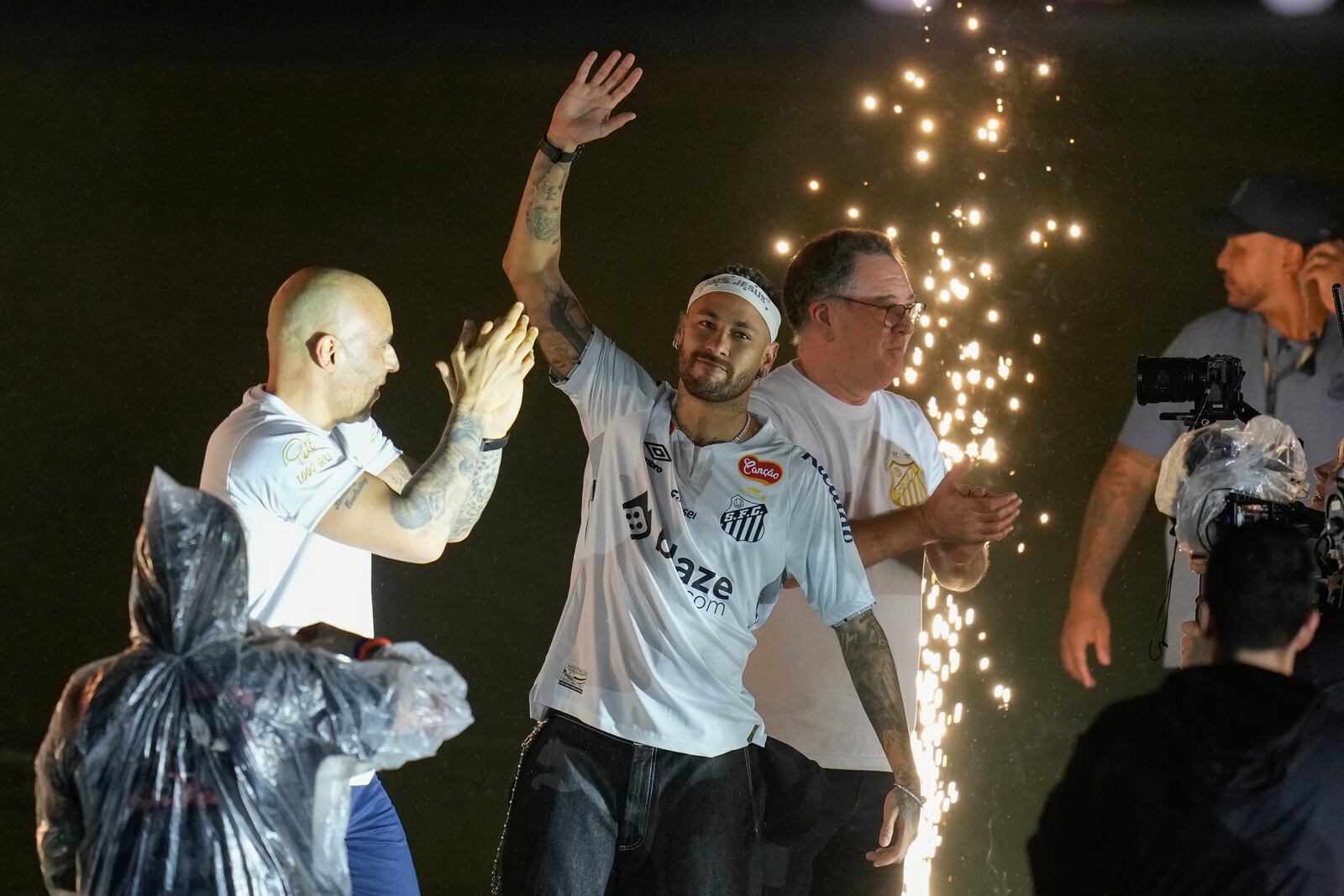 Brazilian soccer player Neymar, center, waves to fans during his presentation ceremony after signing a six-month contract with Santos FC at Vila Belmiro Stadium in Santos, Brazil, Friday, Jan. 31, 2025. (AP Photo/Andre Penner)