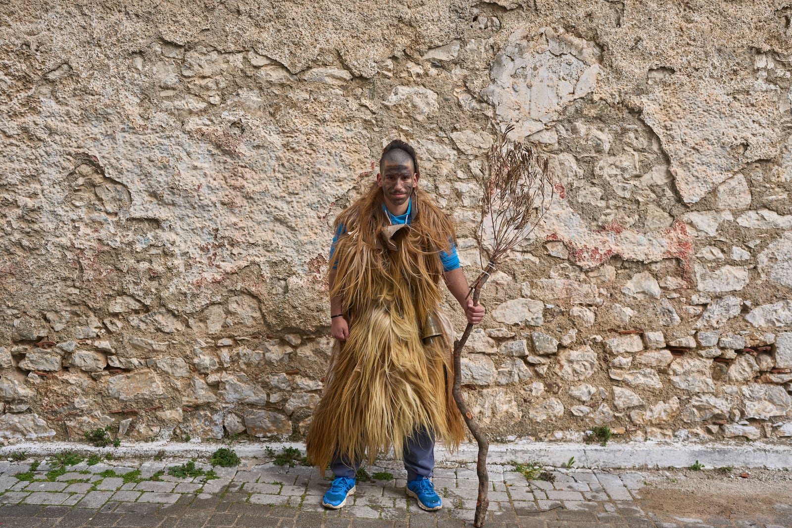 Thanos Papageorgiou, 20, poses for a portrait, dressed in animal skins and heavy bronze bells, as part of carnival celebrations in Distomo, a village in central Greece, on Monday, March 3, 2025. (AP Photo/Petros Giannakouris)