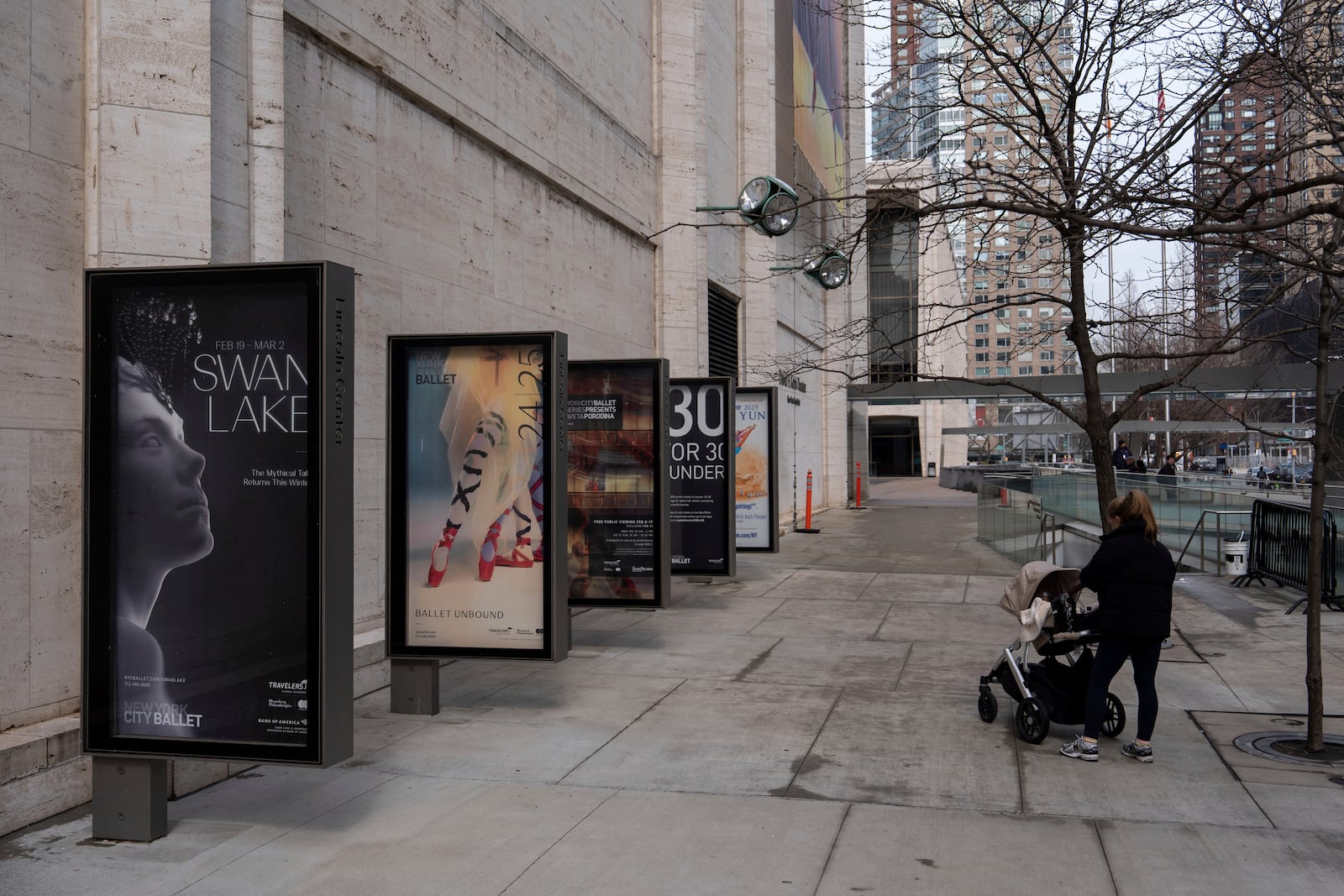 A person walks past a poster for New York City Ballet's "Swan Lake" outside Lincoln Center, Tuesday, Feb. 25, 2025, in New York. (AP Photo/Julia Demaree Nikhinson)