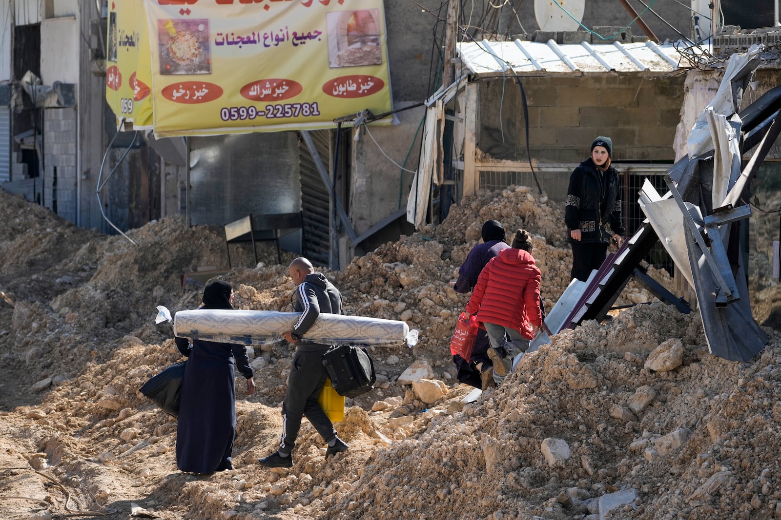 Residents of the West Bank urban refugee camp of Nur Shams evacuate their homes and carry their belongings as the Israeli military continues its operation in the area on Wednesday, Feb. 26, 2025. (AP Photo/Majdi Mohammed)