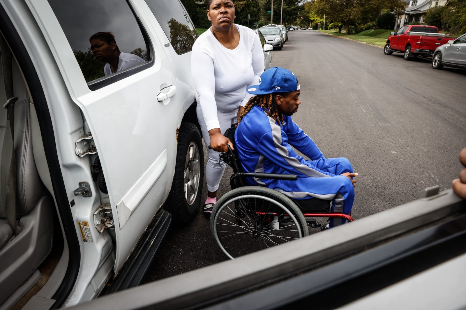 Terri Owensby, left, helps her brother, Clifford Owensby, out of his vehicle Monday Oct. 4, 2021. Clifford Owensby said he is a paraplegic and Dayton police pulled him out of his vehicle during a traffic stop. JIM NOELKER/STAFF