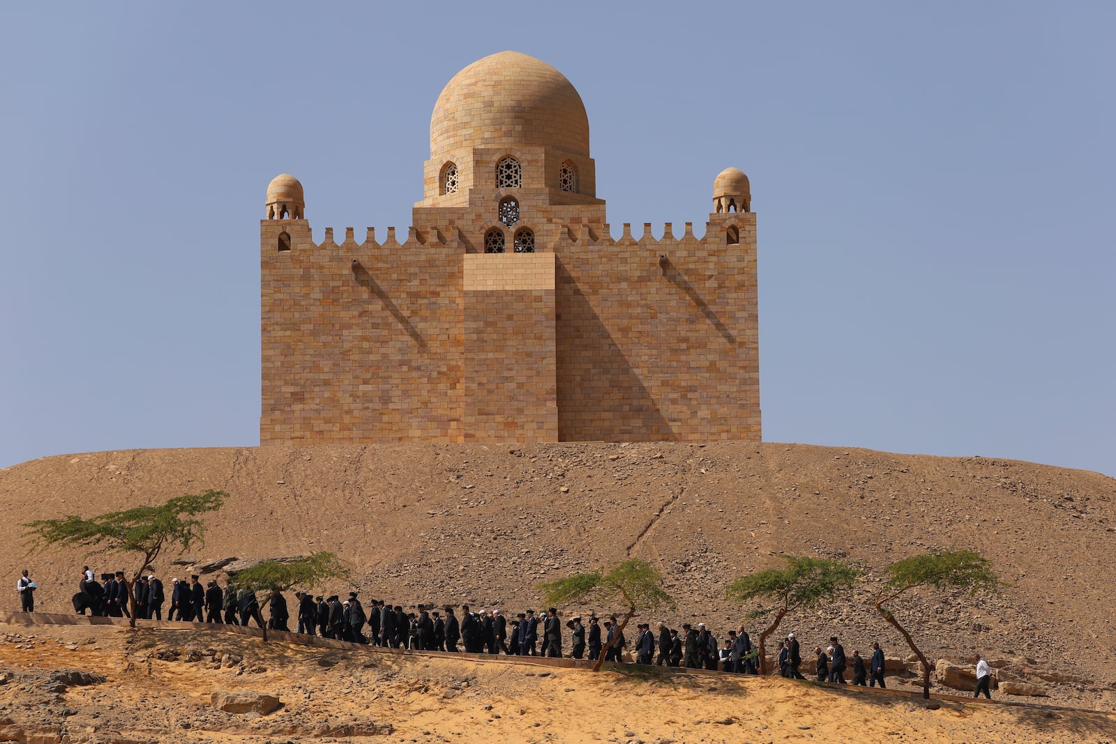 Relatives of Prince Karim Al-Hussaini, the Aga Khan IV and 49th hereditary imam of the Shiite Ismaili Muslims, who died Tuesday in Portugal, walk during a funeral ceremony at the Aga Khan mausoleum, in Aswan, Egypt, Sunday, Feb. 9, 2025. (AP Photo/Haytham Fahmy)