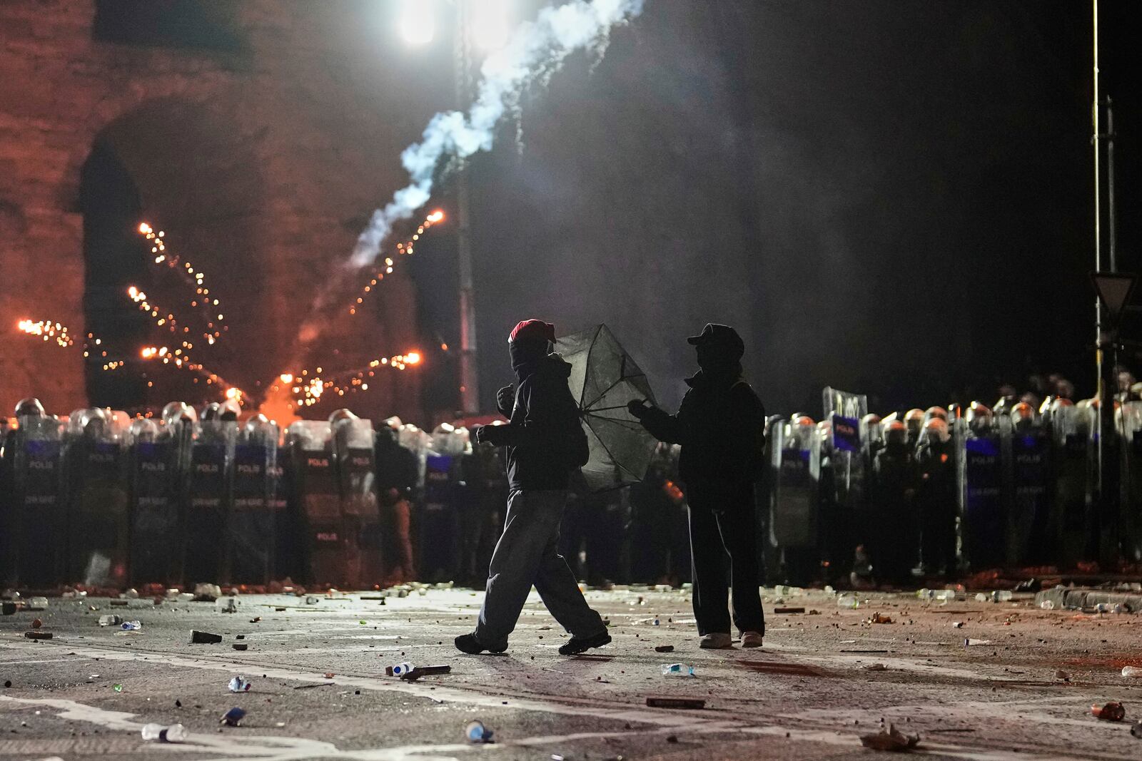 Fireworks thrown by protesters explode over riot police during a protest against the arrest of Istanbul's Mayor Ekrem Imamoglu, in Istanbul, Turkey, Saturday, March 22, 2025. (AP Photo/Khalil Hamra)