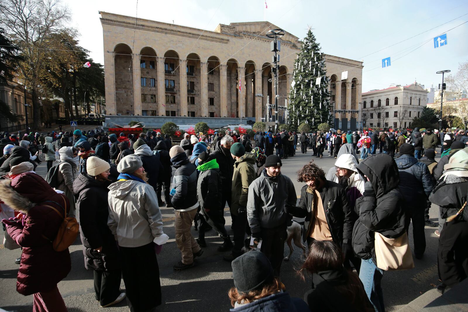 People gather outside the Georgian parliament while the parliament has begun the procedure of the presidential elections, in Tbilisi, Georgia, Saturday, Dec. 14, 2024. (AP Photo/Zurab Tsertsvadze)