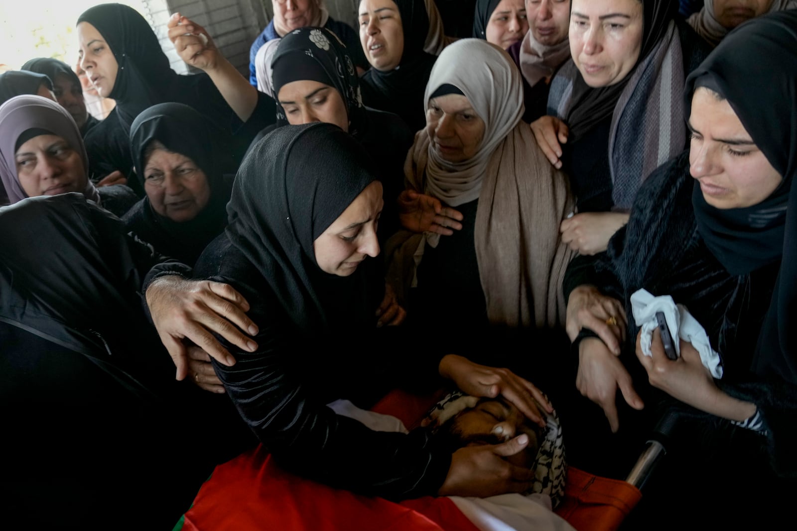 Palestinians attend the funeral of Ahmed Salah, 32, in the village of Kafr Dan, who died after being struck by an Israeli military vehicle in what the army said was an accident during an operation in the occupied West Bank. (AP Photo/Majdi Mohammed)