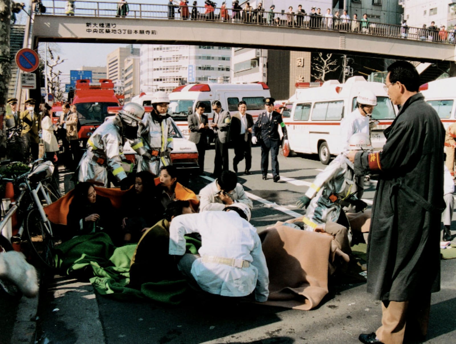 Passengers affected by sarin nerve gas receive medial treatment near a subway station in Tokyo on March 20, 1995. (Kyodo News via AP)