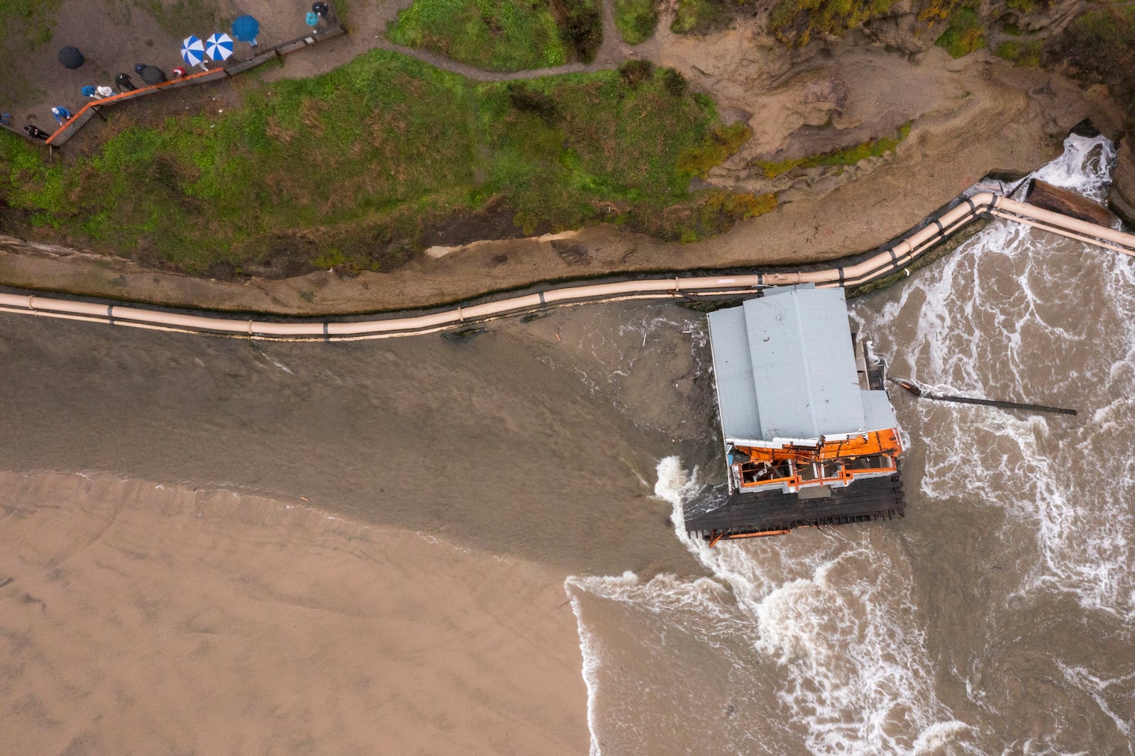 Remnants of a bathroom that fell off the wharf are seen at the mouth of the San Lorenzo River in Santa Cruz, Calif., Tuesday, Dec. 24, 2024. (AP Photo/Nic Coury)