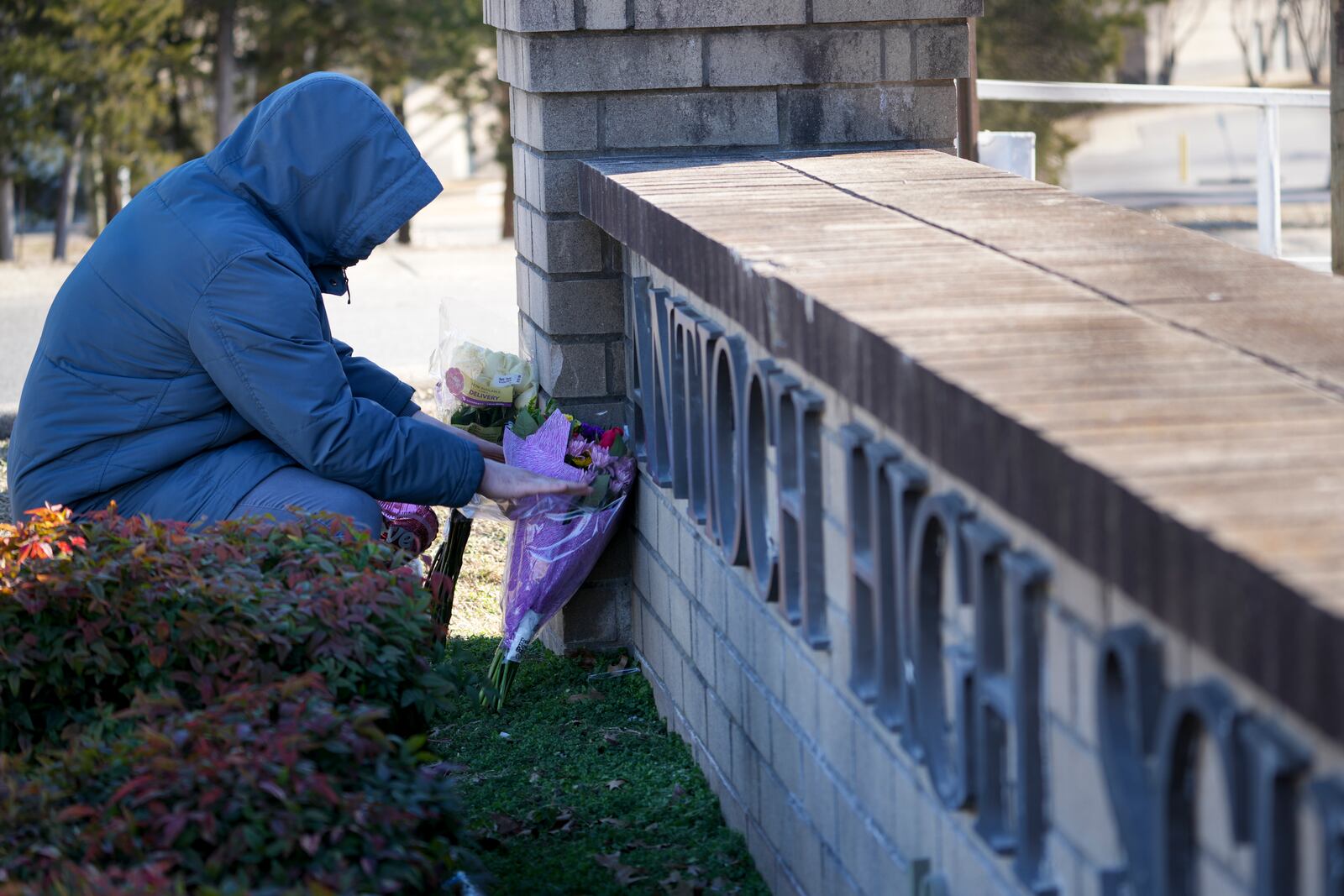 Jordan Hebert leaves flowers at a memorial for victims of a shooting at Antioch High School, Thursday, Jan. 23, 2025, in Nashville, Tenn. (AP Photo/George Walker IV)