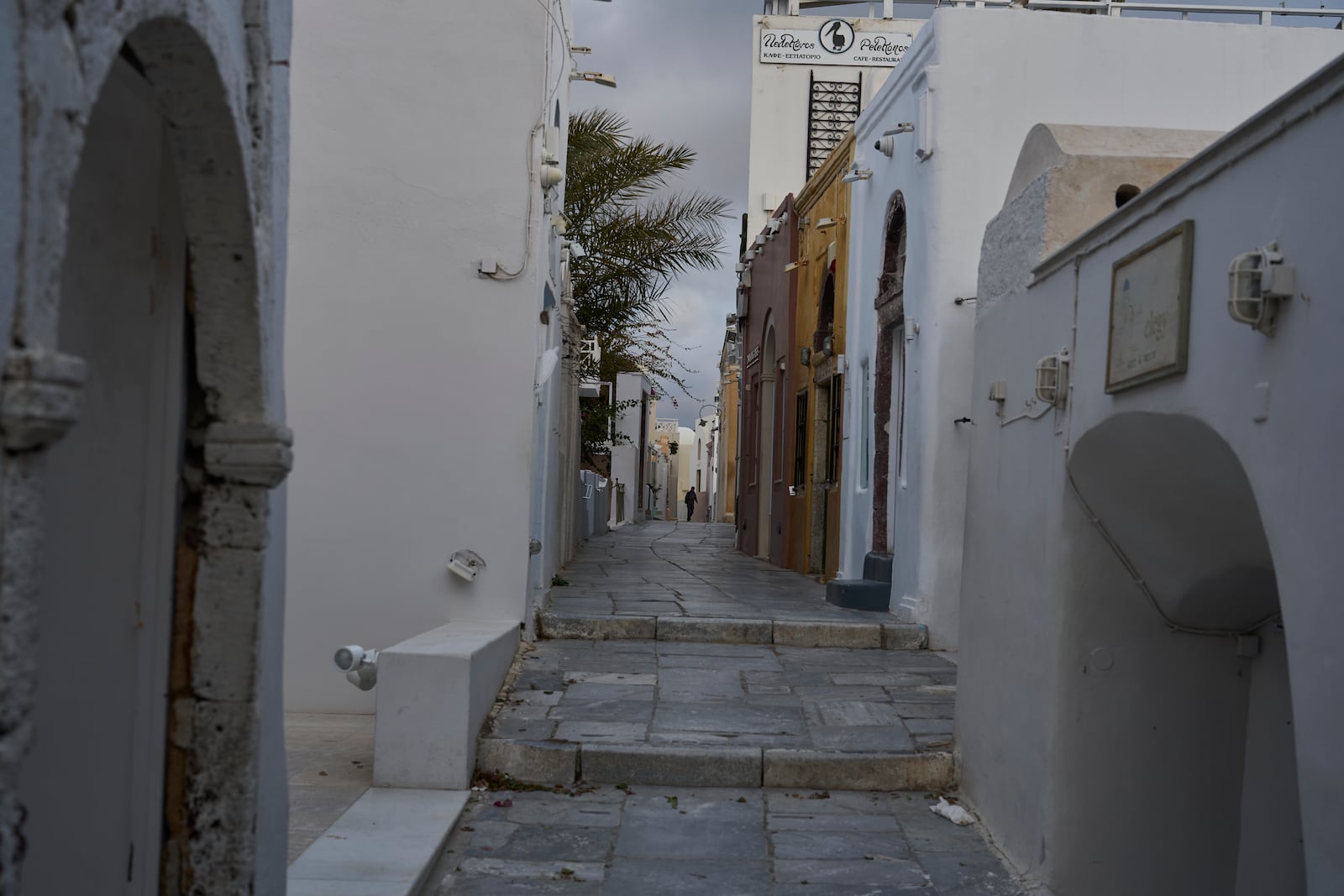 A man walks on an empty street in the town of Oia on the earthquake-struck island of Santorini, Greece, Tuesday, Feb. 4, 2025. (AP Photo/Petros Giannakouris)