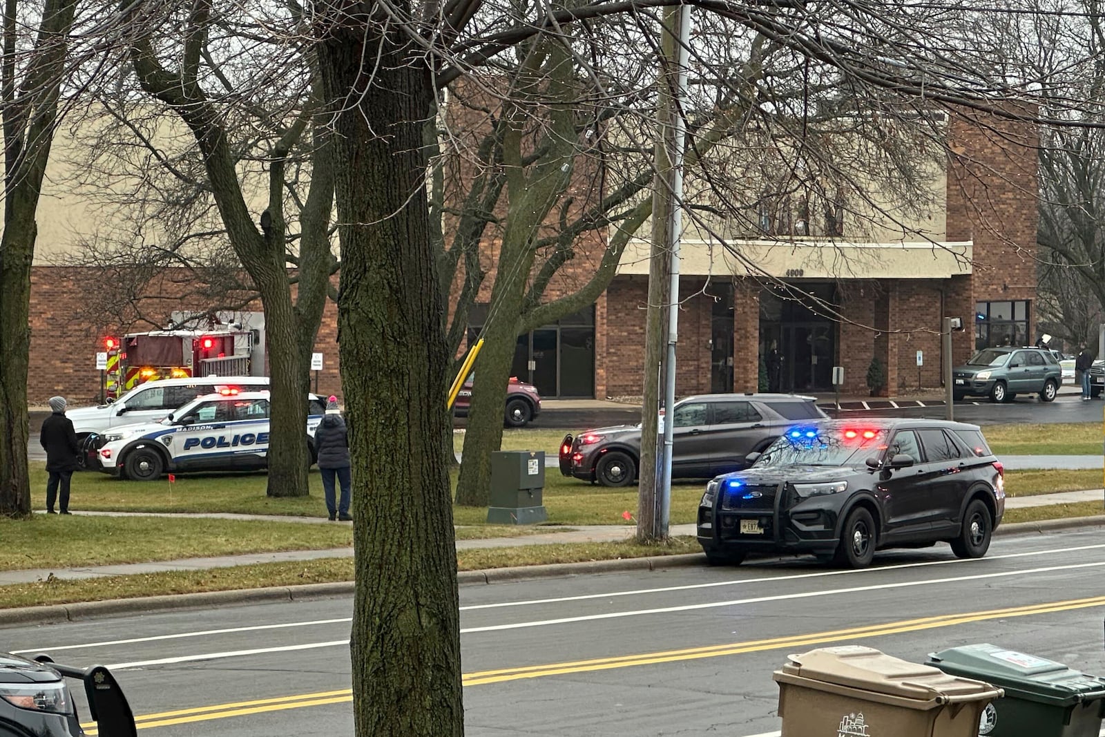 Emergency vehicles are parked outside the Abundant Life Christian School in Madison, Wis., where multiple injuries were reported following a shooting, Monday, Dec. 16, 2024. (AP Photo/Kathleen Foody)