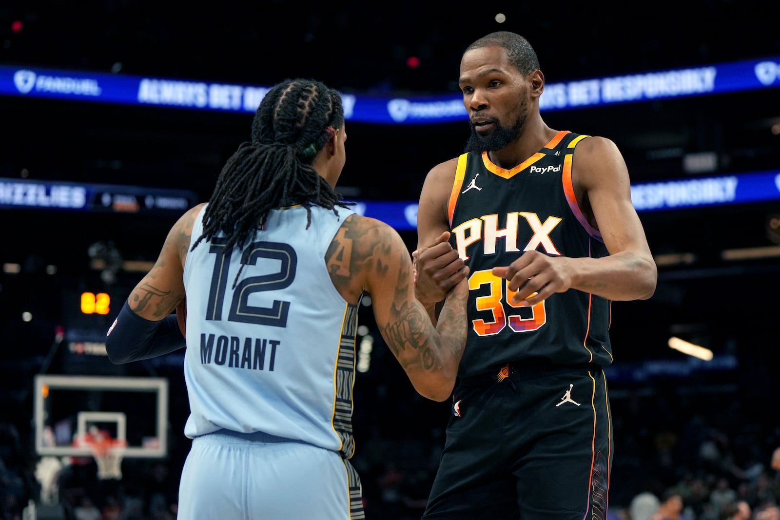 Memphis Grizzlies guard Ja Morant (12) and Phoenix Suns forward Kevin Durant (35) shake hands after an NBA basketball game, Tuesday, Feb. 11, 2025, in Phoenix. (AP Photo/Rick Scuteri)