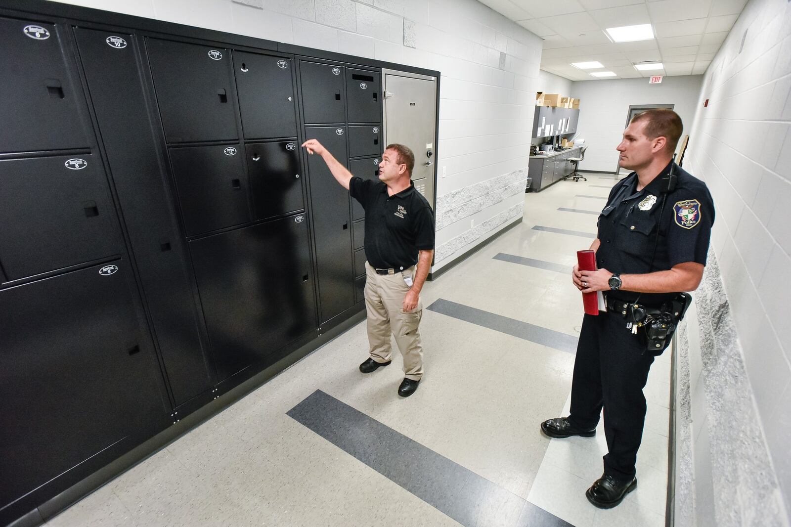 West Chester Police officers Ernie Malott, left, and Joshua Cupp show the lockers used to transfer evidence into the evidence room at the West Chester Police Department. 