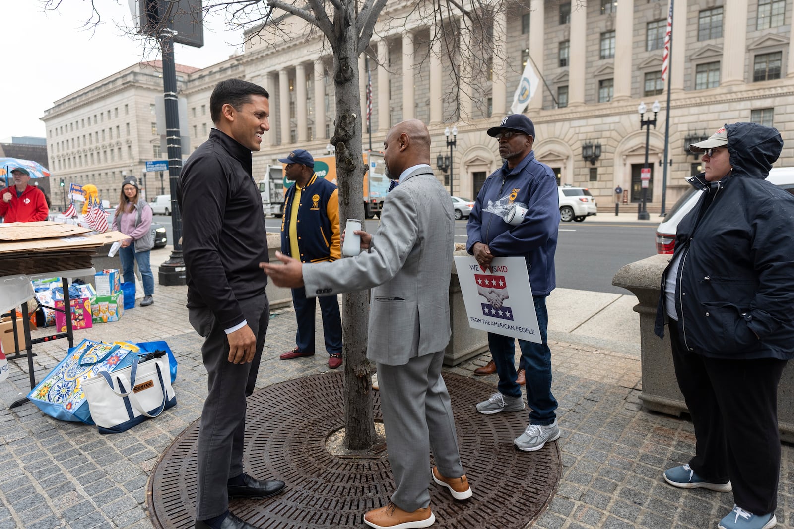 Rajiv Shah, the former United States Agency for International Development (USAID) Administrator, left, talks to former USAID workers gathered outside USAID's headquarters in Washington, Thursday, Feb. 27, 2025. (AP Photo/Manuel Balce Ceneta)