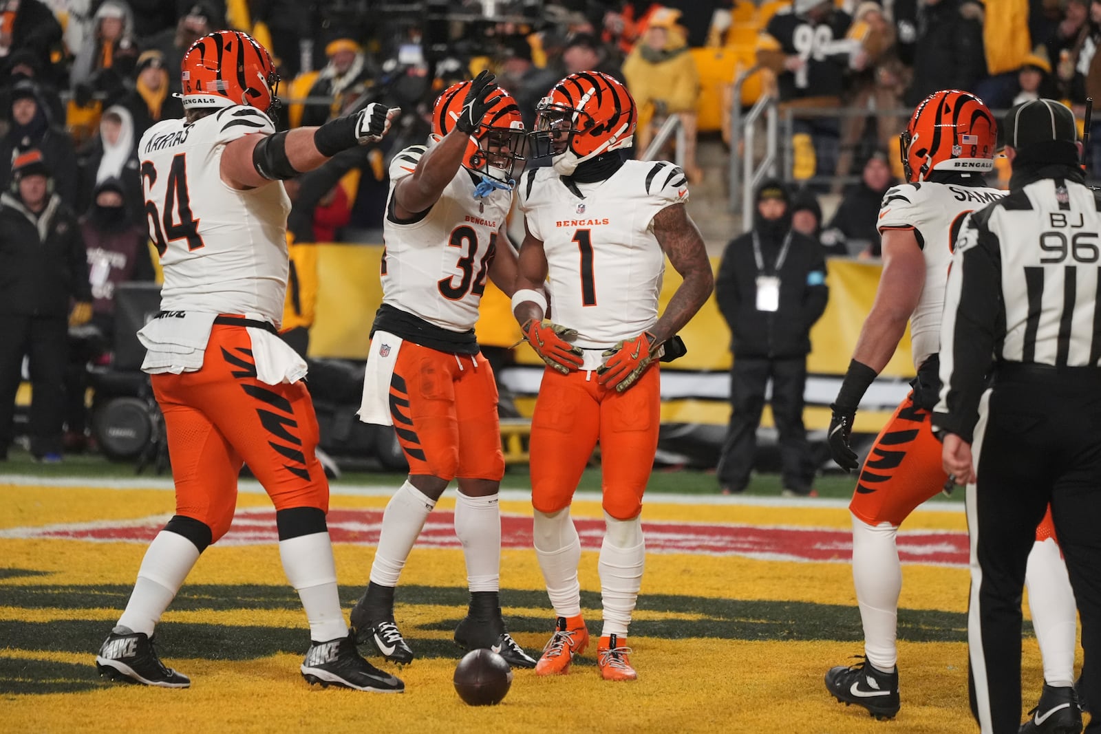 Cincinnati Bengals wide receiver Ja'Marr Chase (1) celebrates scoring a touchdown with center Ted Karras (64) and running back Khalil Herbert (34) during the first half of an NFL football game in Pittsburgh, Saturday, Jan. 4, 2025. (AP Photo/Gene J. Puskar)