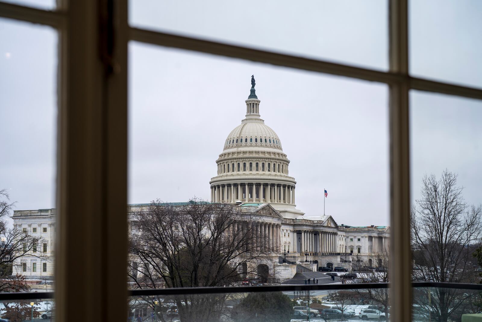 The Capitol is seen framed through a window in the Cannon House Office Building on Capitol Hill in Washington, Thursday, Feb. 13, 2025. (AP Photo/J. Scott Applewhite)