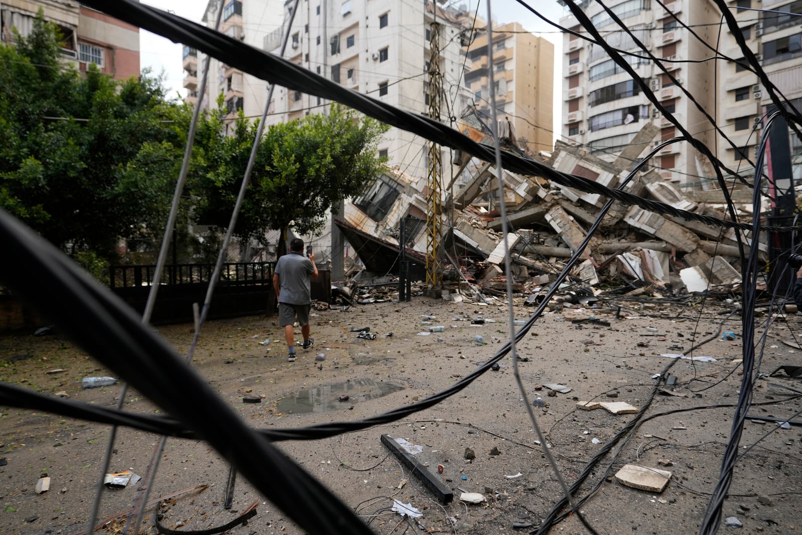 A man checks the damaged buildings at the site of an Israeli airstrike in Beirut's southern suburb, Lebanon, Tuesday, Oct. 1, 2024. (AP Photo/Hassan Ammar)