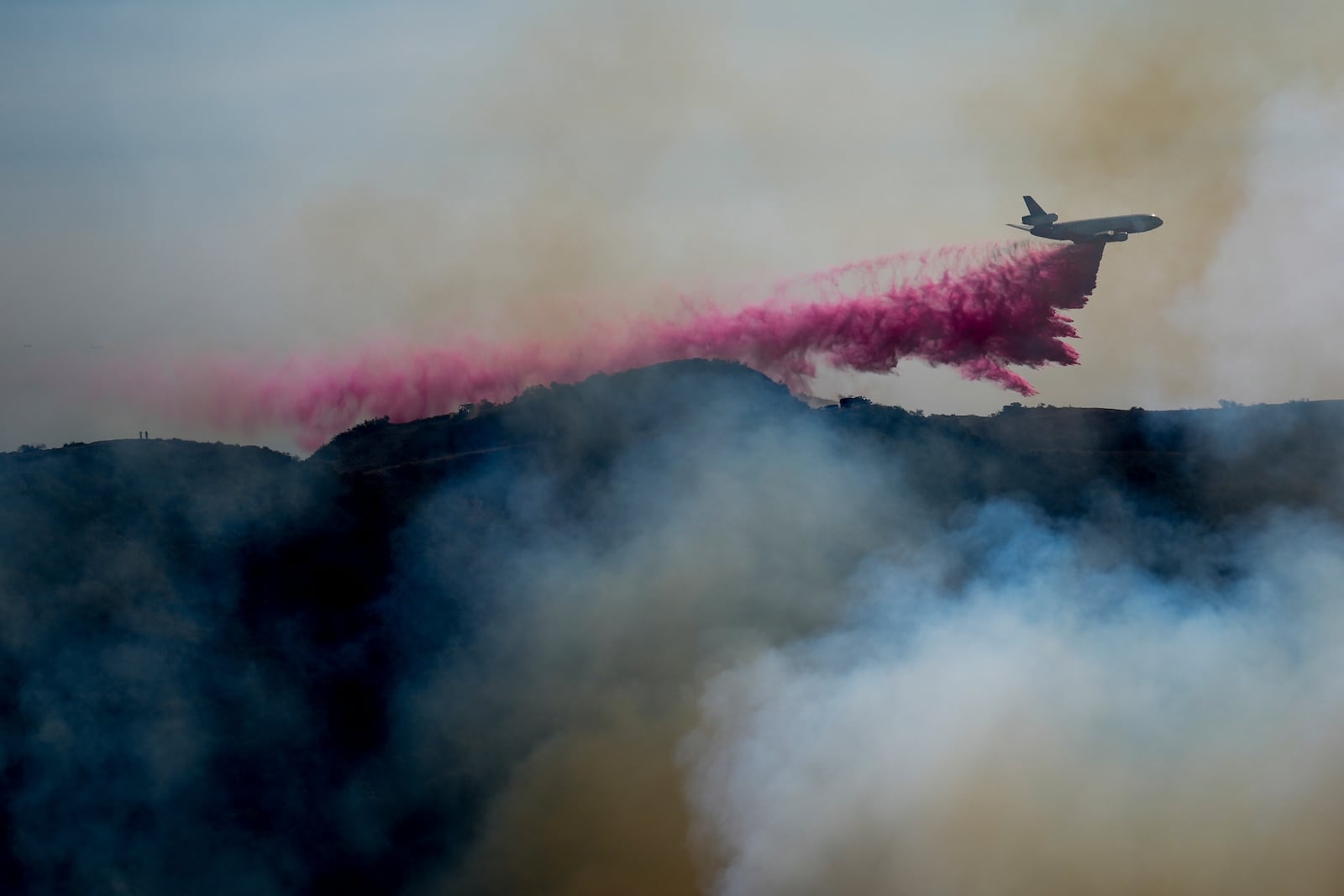 FILE - Fire retardant is dropped by an air tanker on the Palisades Fire in the outskirts of the Pacific Palisades neighborhood of Los Angeles, Jan. 10, 2025. (AP Photo/Eric Thayer, File)