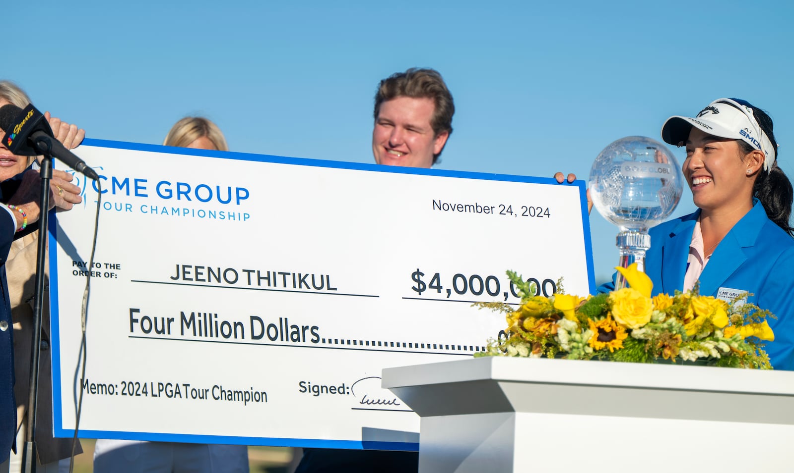 Jeeno Thitikul, right, smiles on the 18th green after getting a $4,000,000 check for winning the LPGA CME Group Tour Championship golf tournament Sunday, Nov. 24, 2024, in Naples, Fla. (AP Photo/Chris Tilley)