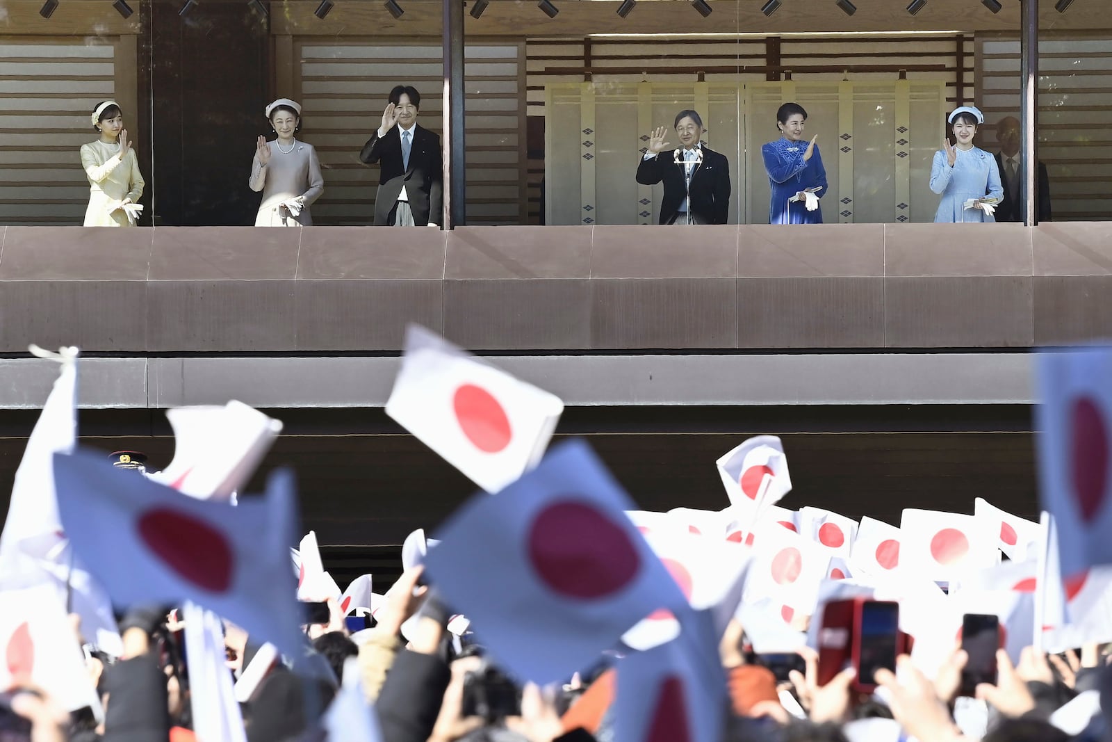 Japanese Emperor Naruhito, third right, accompanied by Empress Masako, second right, their daughter Princess Aiko, right, Crown Prince Akishino, Crown Princess Kiko, second left, and Princess Kako, waves to well-wishers from the balcony of the Imperial Palace in Tokyo on the emperor's 65th birthday, Sunday, Feb. 23, 2025. (Kyodo News via AP)