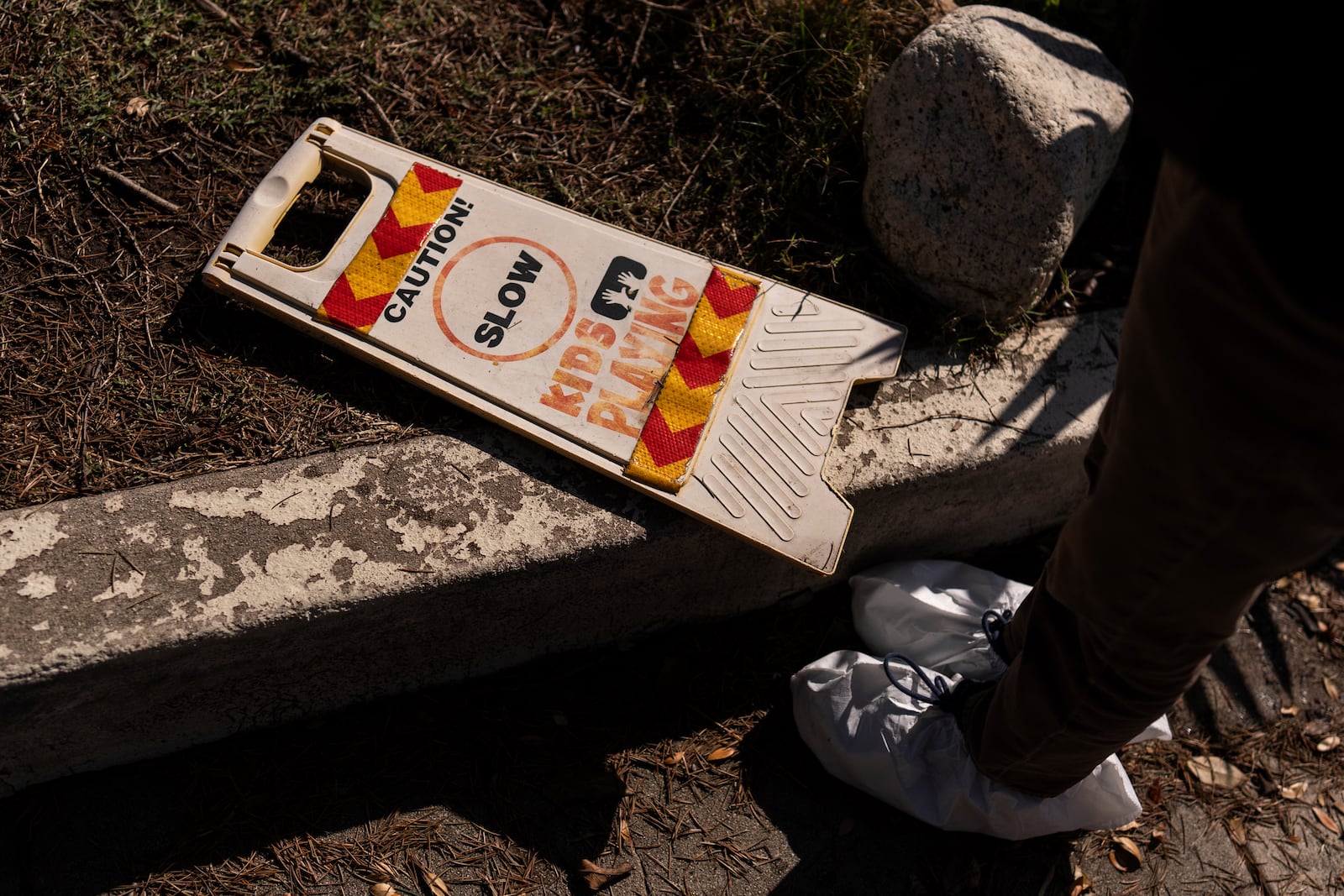 Ceiba Phillips, an 11-year-old Eaton Fire evacuee, looks at a safety sign at his best friend's home, which was gutted by the fire, during his first visit to his home and neighborhood since the fire in Altadena, Calif., Saturday, Feb. 8, 2025. (AP Photo/Jae C. Hong)