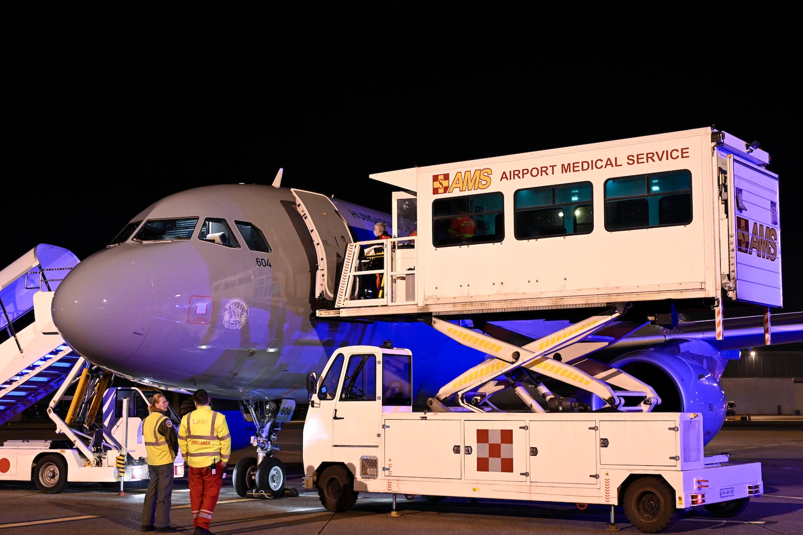 An ambulance carriage is lifted to the door of an aircraft as survivors of the Kocani night club fire, treated with burn injuries, are transported to hospital upon arrival by a Hungarian Air Force MH Airbus A319 jet at the capital city's international airport in Budapest, Hungary, early Wednesday, March 19, 2025. (Peter Lakatos/MTI via AP)