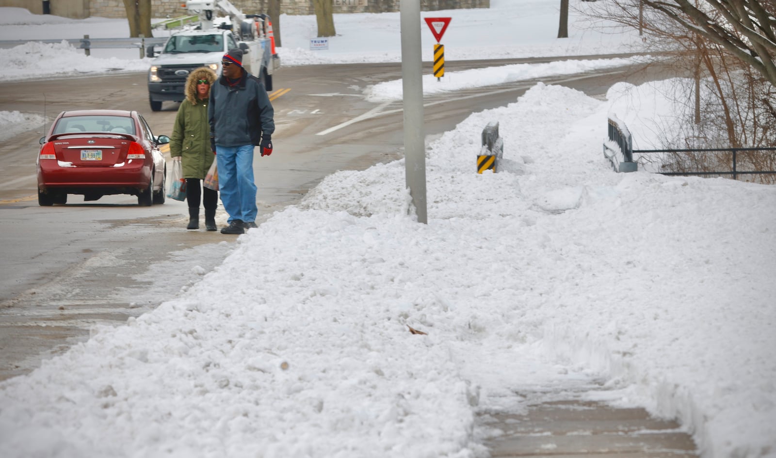 Main roads were mostly clear by Wednesday, Jan. 8, 2025, but lots of sidewalks remain snow covered, leading pedestrians to walk in the street, like this pair on West Market Street in Xenia. MARSHALL GORBY \STAFF