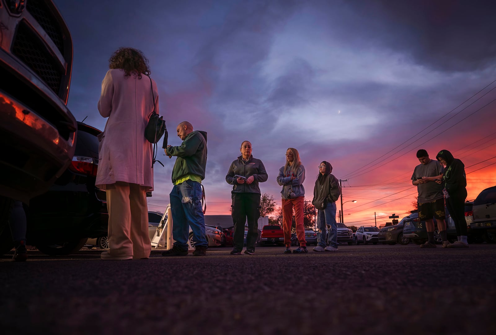 People wait in line to vote on Election Day at the Bernalillo County Visitor Center while the sunsets in the South Valley of Albuquerque, N.M., on Tuesday, Nov. 5, 2024. (Chancey Bush/The Albuquerque Journal via AP)