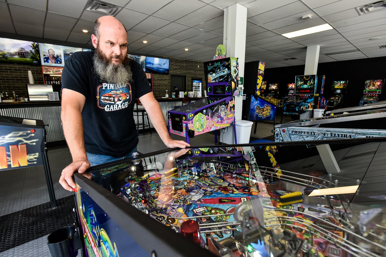 Pinball Garage owner Brad Baker plays the brand new Teenage Mutant Ninja Turtles pinball game Thursday, June 25, 2020. Pinball Garage is now open in downtown Hamilton and offers a large selection of pinball machines to play along with a bar with rotating beer selection. NICK GRAHAM / STAFF