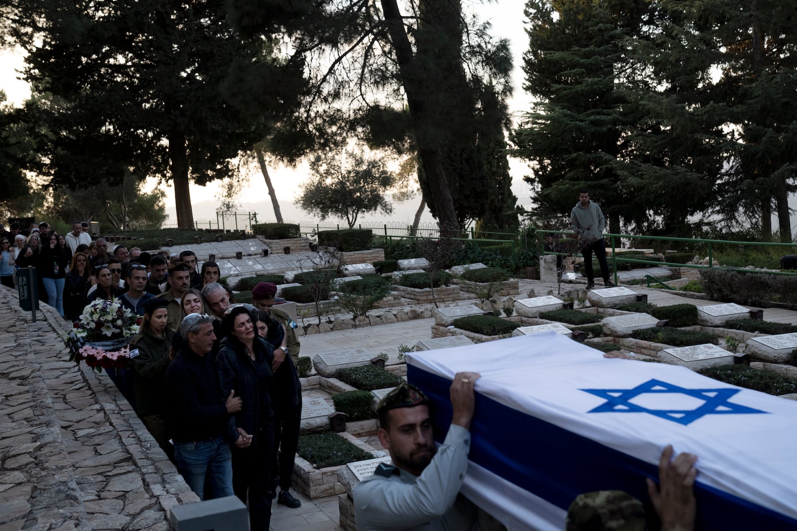 The family of Israeli Defense Forces Sgt. First Class (res.) Roi Sasson, who was killed in action in the Gaza Strip, walk behind his coffin during his funeral at Mt. Herzl military cemetery in Jerusalem, Wednesday, Nov. 20, 2024. (AP Photo/Maya Alleruzzo)