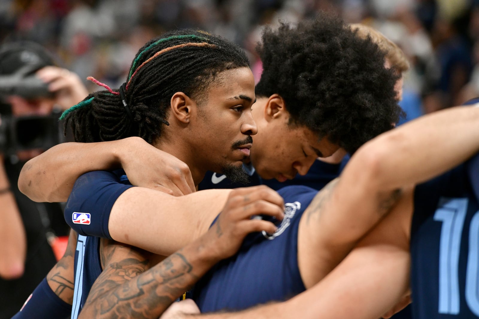 Memphis Grizzlies guard Ja Morant, left, forward Jaylen Wells huddle with their team after a man collapsed courtside just before the start of an NBA basketball game against the San Antonio Spurs, Monday, Feb. 3, 2025, in Memphis, Tenn. (AP Photo/Brandon Dill)