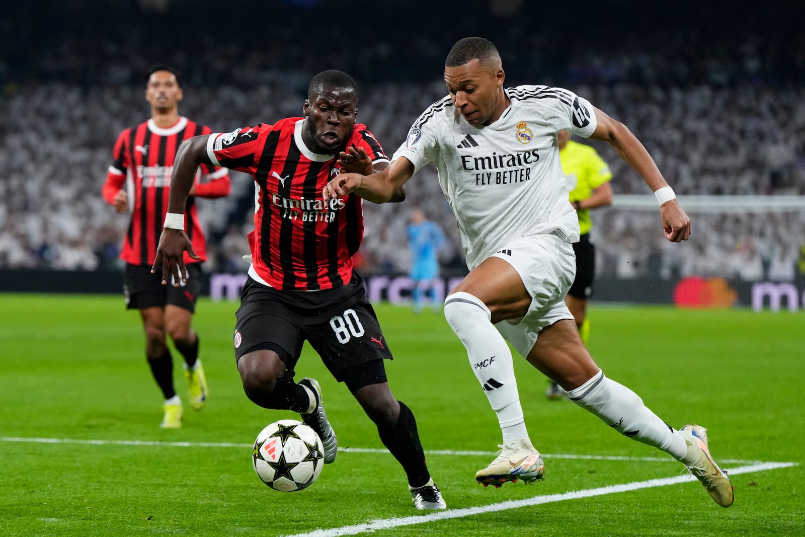 Real Madrid's Kylian Mbappe, right, and AC Milan's Yunus Musah battle for the ball during the Champions League opening phase soccer match at the Santiago Bernabeu stadium in Madrid, Spain, Tuesday, Nov. 5, 2024. (AP Photo/Manu Fernandez)