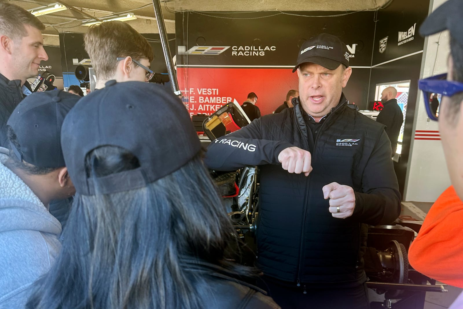 Chris Mitchum, director of motorsports at Action Express Racing shows students from two Volusia County high schools a Cadillac sports car, Friday, Jan 17, 2025, at Daytona International Speedway in Daytona Beach, Fla., as part of an immersive experience to show the teens STEM opportunities exist in motorsports. (AP Photo/Jenna Fryer)