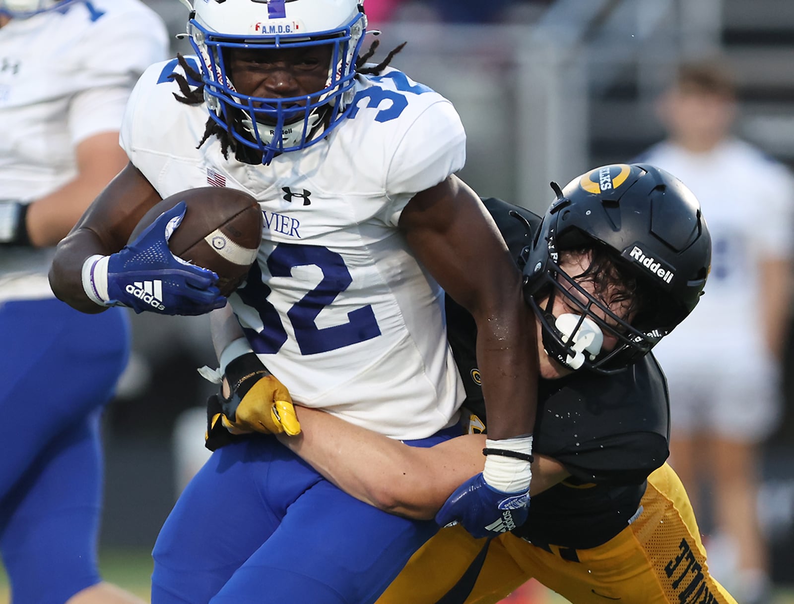 Centerville's Jacob Buhler tackles St. Xavier's Elijah Steele during a game earlier this season. BILL LACKEY/SAFF